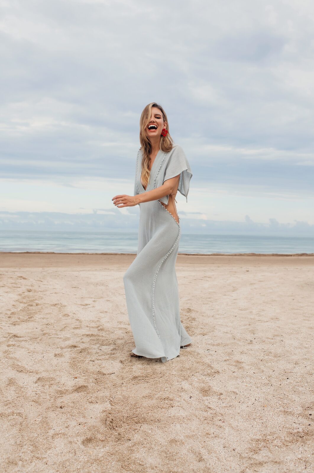 A Red Market Miami guest laughing by the ocean, in soft coastal light
