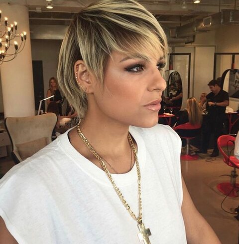 A client with a short blonde cut at a styling station with red chairs and mirrors, Red Market Miami, Bal Harbour Shops