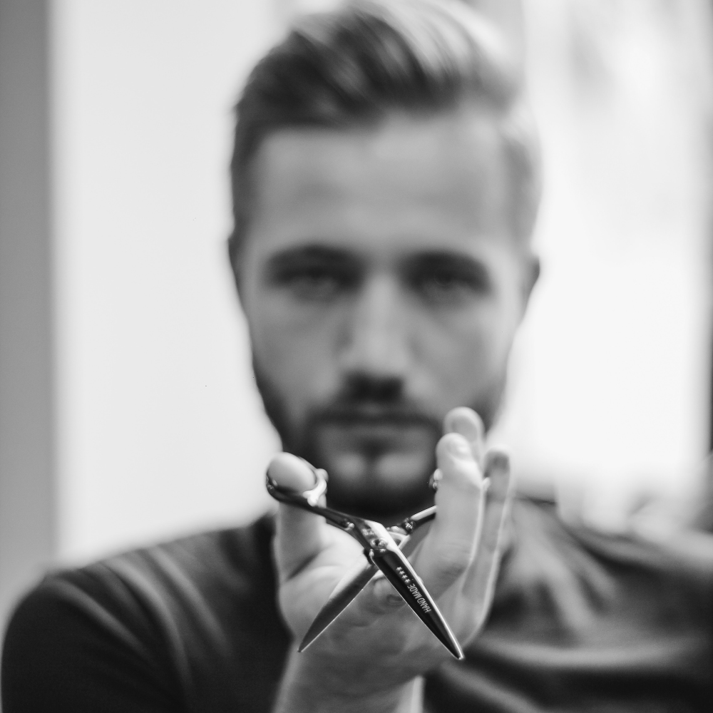 A Red Market stylist with shears, seen in black and white