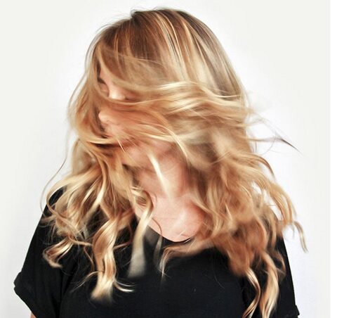 A client tossing long blonde hair, styled at Red Market Miami