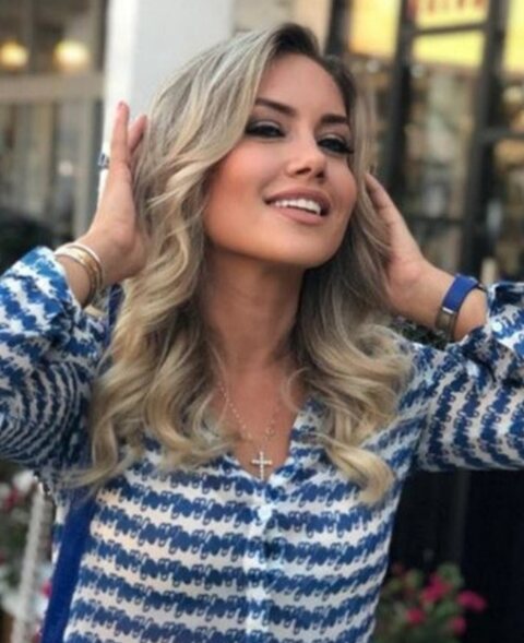 A client with long blonde waves outside the salon at Bal Harbour Shops