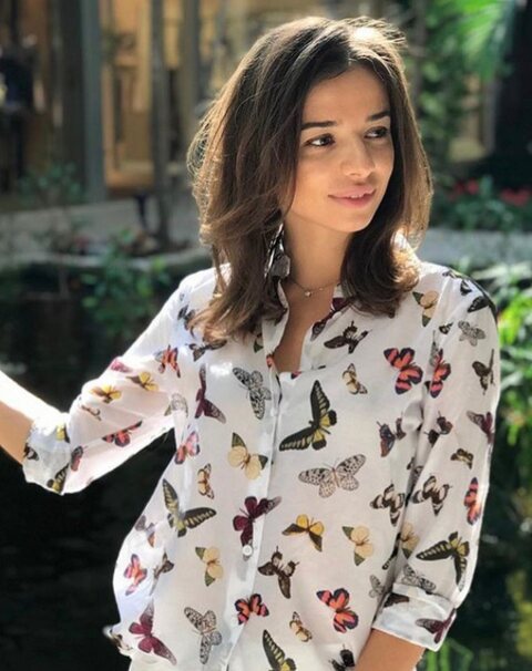 A client in a butterfly-print shirt with long brown curls at Bal Harbour Shops